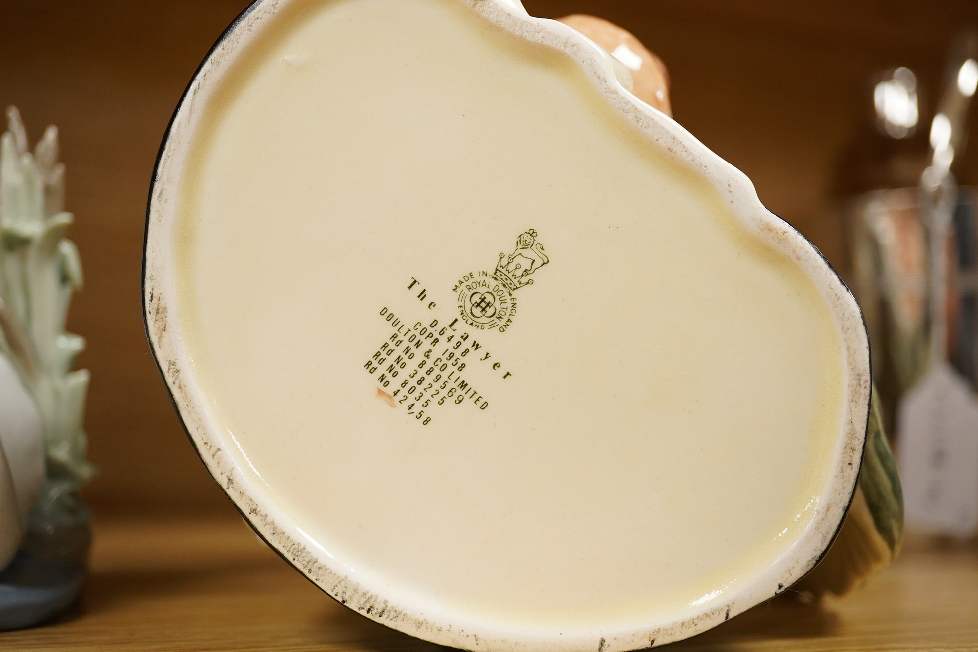 Four Lladro and Nao figures and a Doulton Toby jug, The Lawyer, largest 20cm high